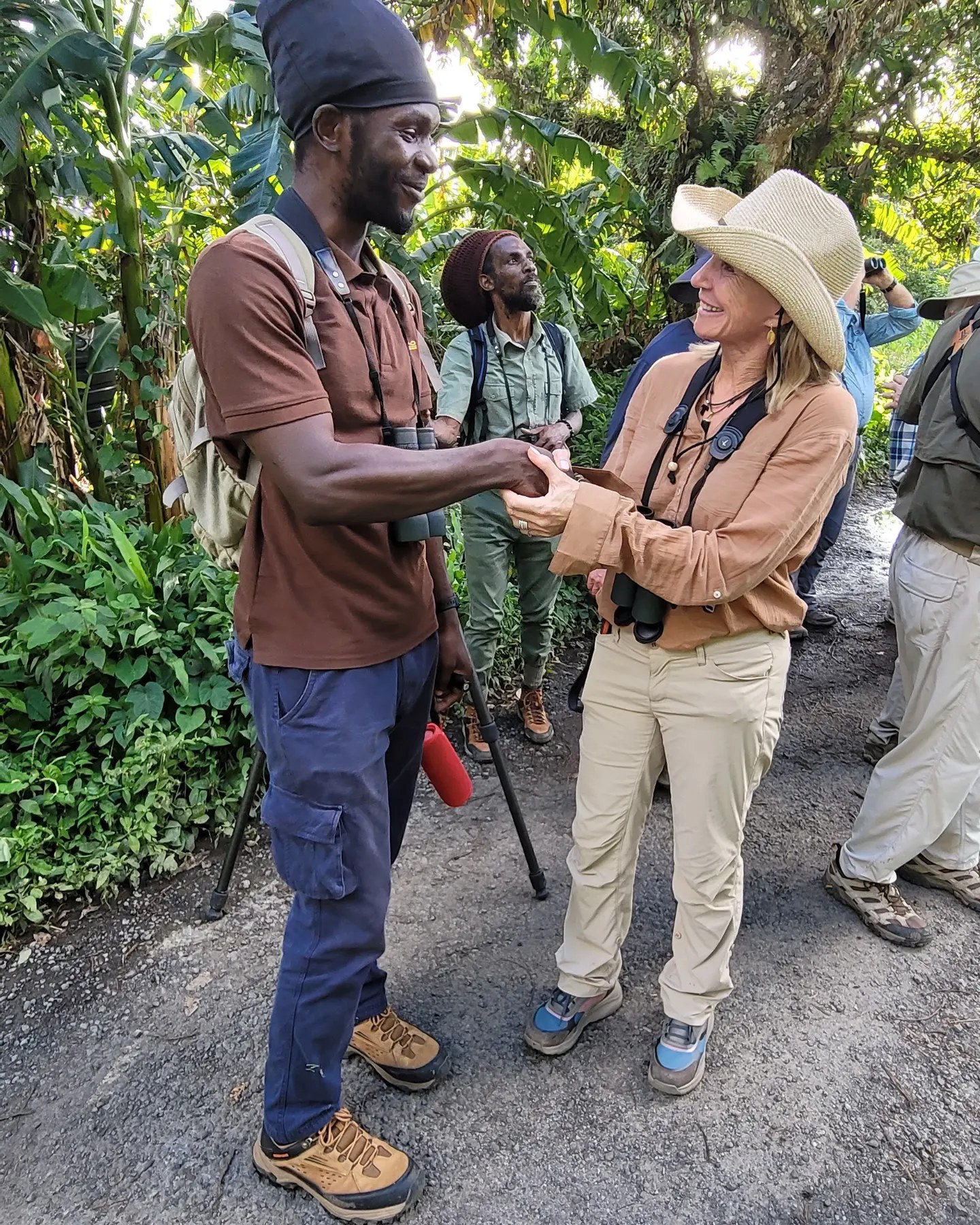 A local wildlife guide welcoming and speaking with a visitor on a rainforest trail
